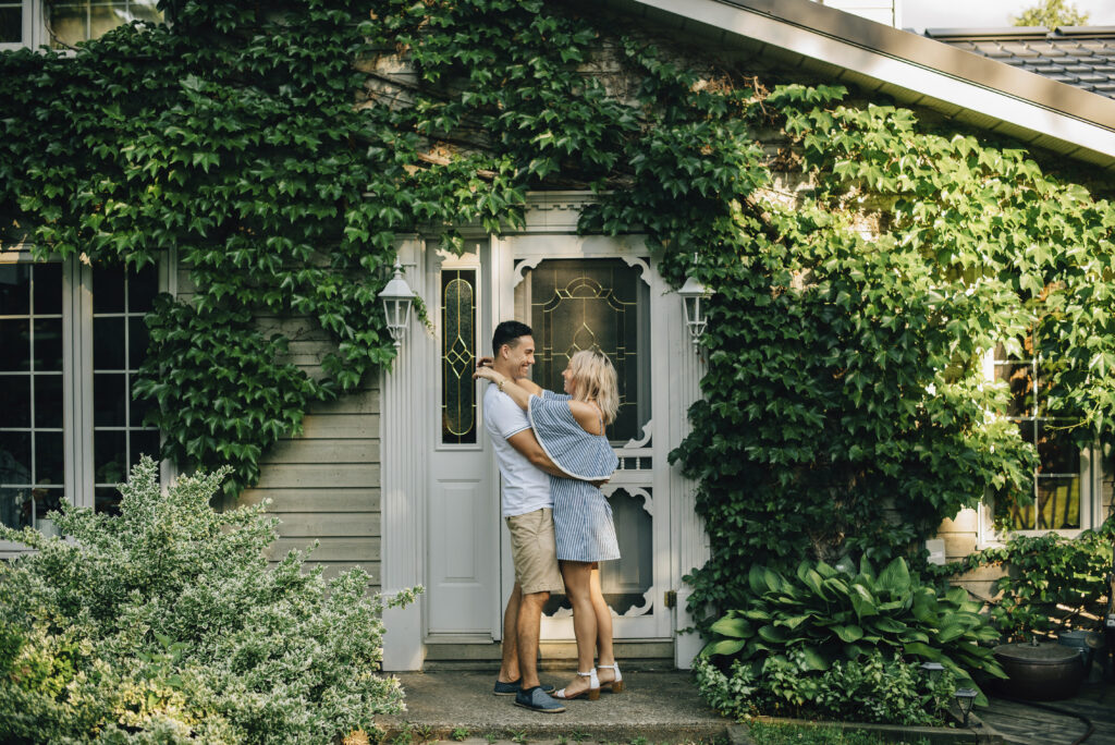 Couple reviewing home buying documents in front of a Maryland residential home